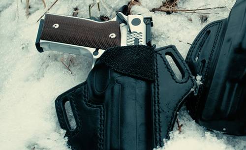 a black outside the waistband holster for 1911 in snow