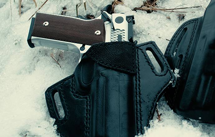 a black outside the waistband holster for 1911 in snow