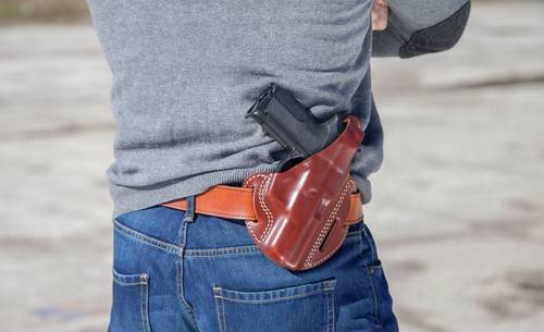 A man carrying an outside the waistband holster