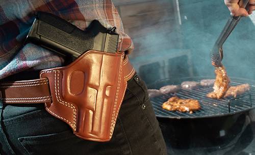 A man with an OWB holster barbecuing