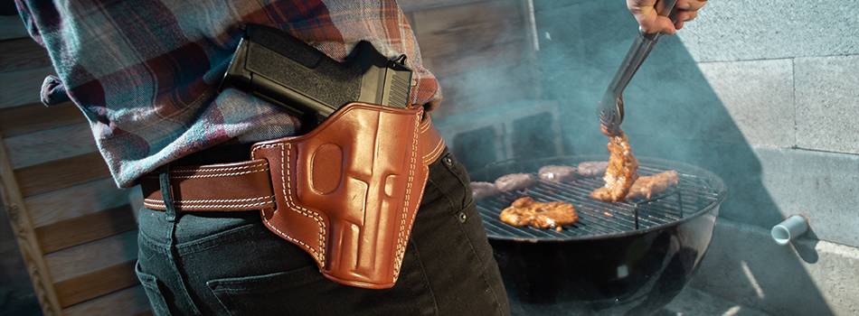 A man with an OWB holster barbecuing