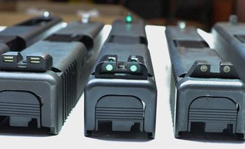 5 glock slides on a desk