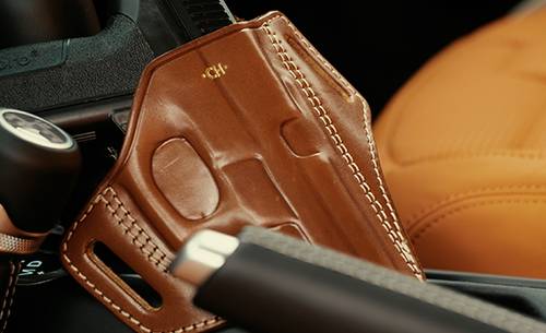 a gun in a holster kept in a car console