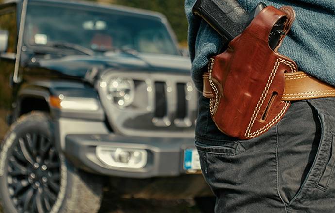 A gun in front of a car with a holster and gun