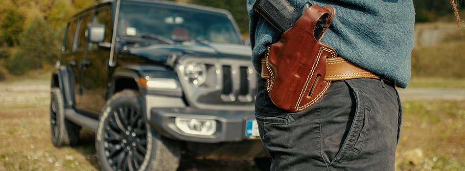 A gun in front of a car with a holster and gun