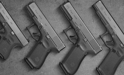 Set of 4 Glock pistols of different size with grips on