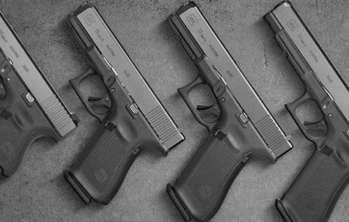 Set of 4 Glock pistols of different size with grips on