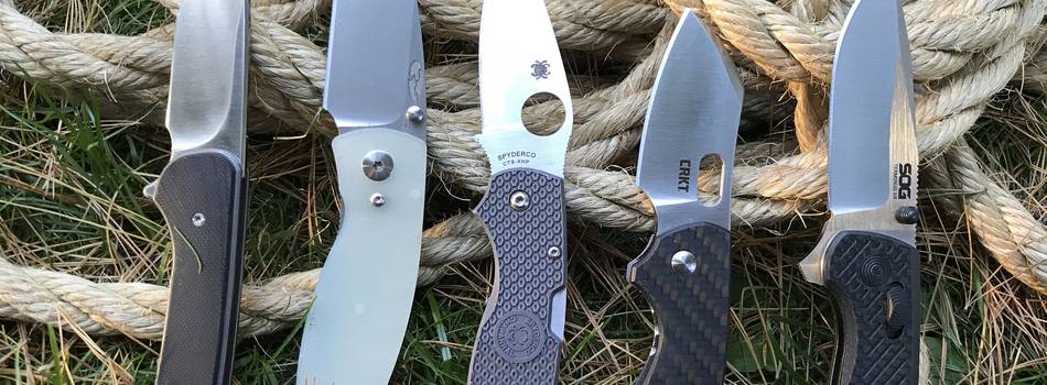 5 EDC knives on grass and ropes