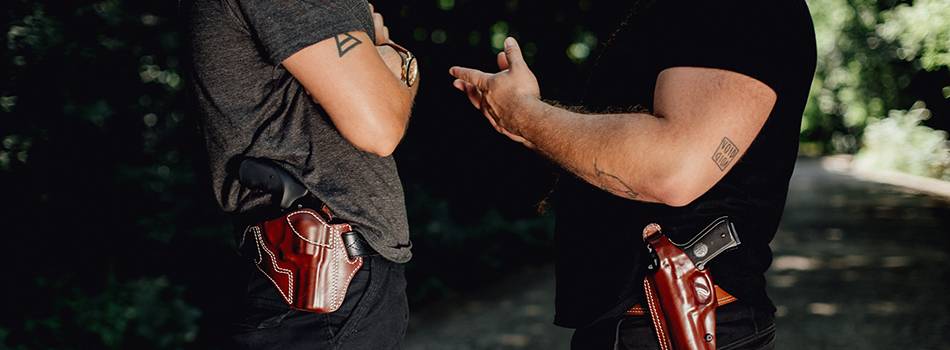 two guys talking about something important with holsters on