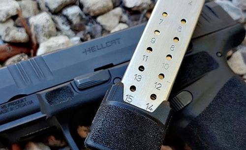 Springfield Hellcat pistol with a magazine lying on the ground