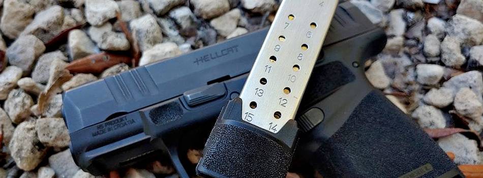 Springfield Hellcat pistol with a magazine lying on the ground