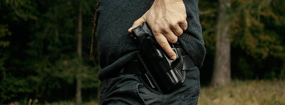 A guy drawing his gun from a left handed holster