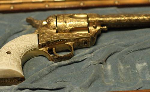 Golden Colt Single Action Army revolver in a gun case