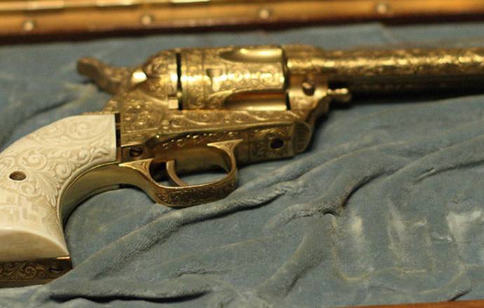 Golden Colt Single Action Army revolver in a gun case