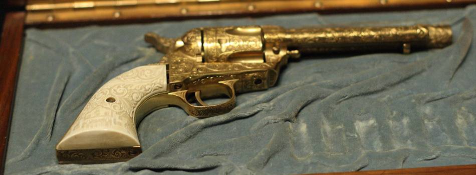 Golden Colt Single Action Army revolver in a gun case