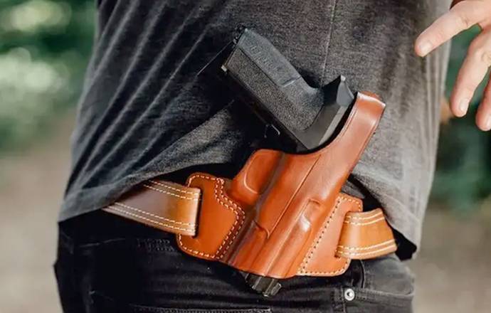 A man with a owb holster strapped to his belt