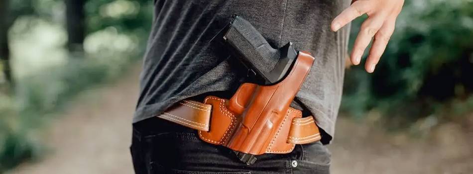 A man with a owb holster strapped to his belt