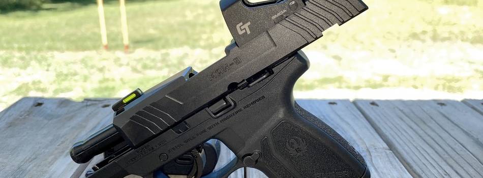 A Ruger Max 9 semi auto pistol with a red dot sight installed to its slide and a racked slide