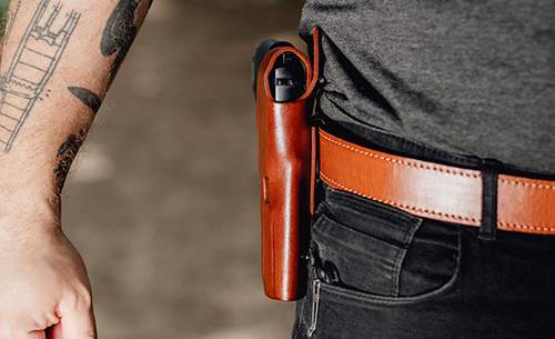 A man with a owb holster strapped to his belt