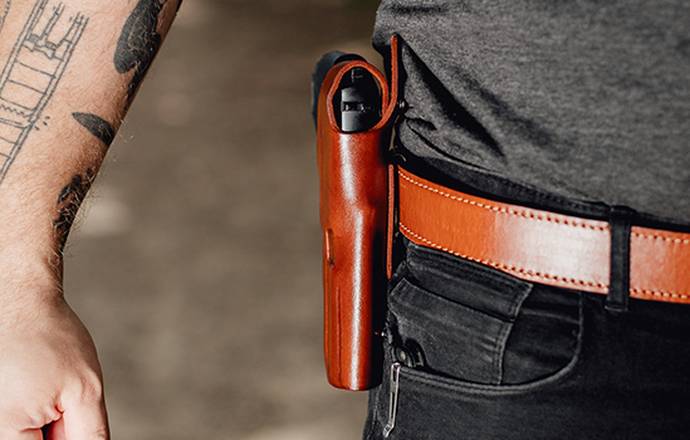 A man with a owb holster strapped to his belt