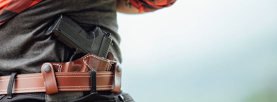 A guy with a custom inside the waistband leather holster, with his shirt up, the gun and holster are partially visible