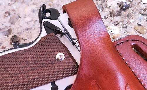 A 1911 smith & wesson pistol in cocked and locked condition in a mahogany leather holster