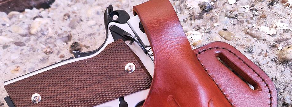 A 1911 smith & wesson pistol in cocked and locked condition in a mahogany leather holster