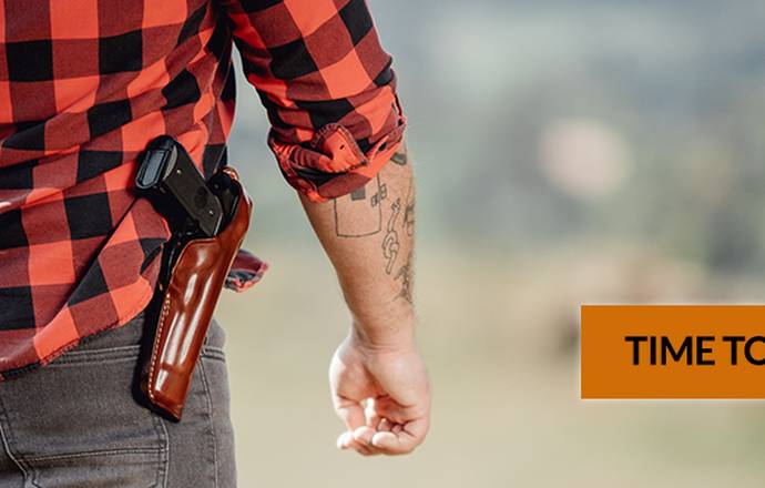 a guy in a flannel shirt with a custom leather holster and a semi automatic pistol