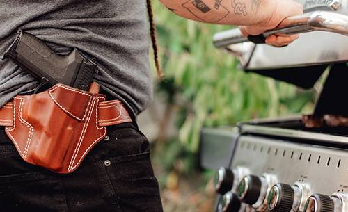 a guy with a mahogany leather holster roasting beef steaks