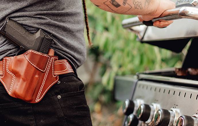 a guy with a mahogany leather holster roasting beef steaks