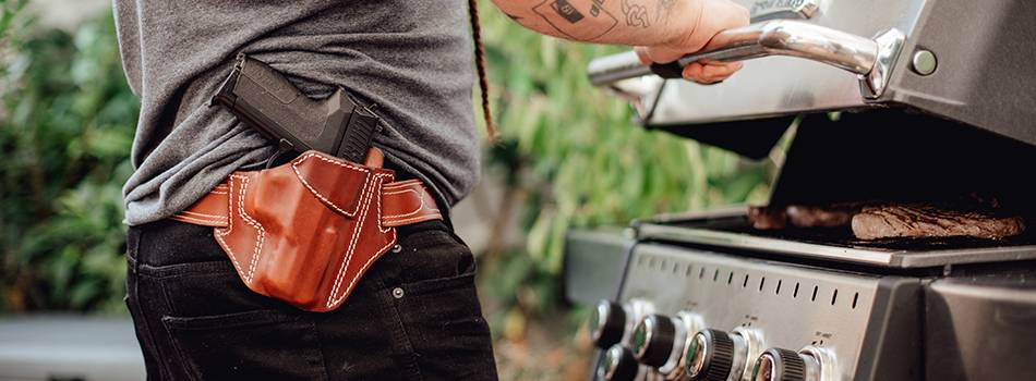 a guy with a mahogany leather holster roasting beef steaks