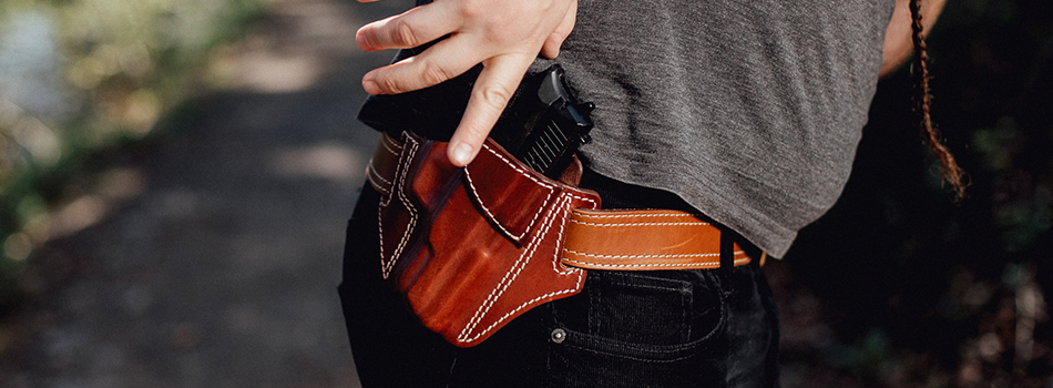 a guy drawing his gun from an outside the waistband leather holster