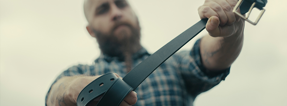 a guy stretching his black leather gun belt