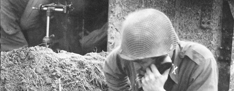 Soldier communicating with HQ via a field telephone