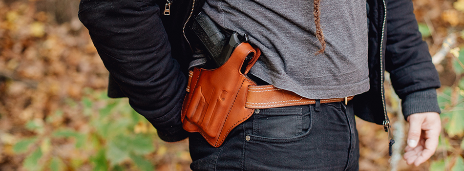 a guy carrying his sig p365 xl with light in a custom leather holster