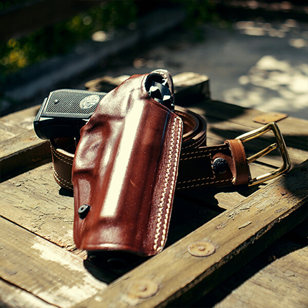 a custom leather OWB holster and a leather gun belt on a treasure chest