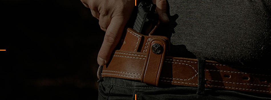 Leather belt holster with a handgun being drawn from the hip.