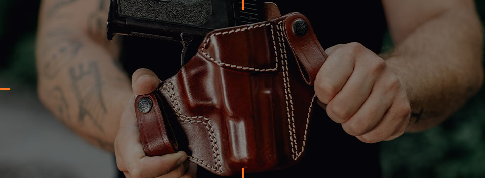 Man holding a brown leather IWB holster with a handgun.