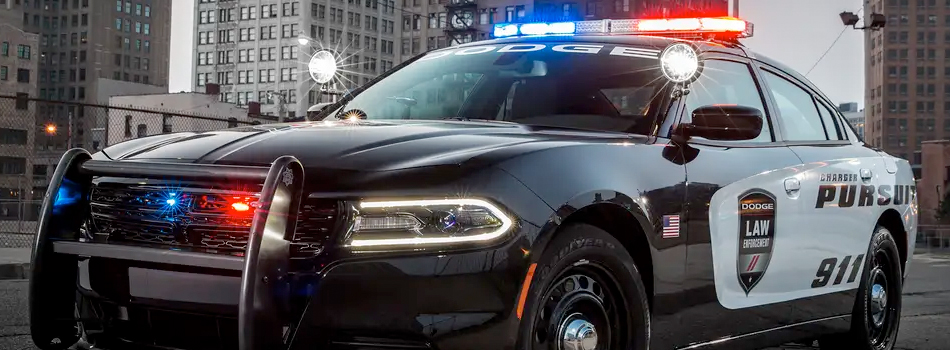 Black Police Car with lights on in the streets of a big city