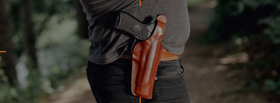 Man wearing a brown leather OWB holster with a handgun on the belt.