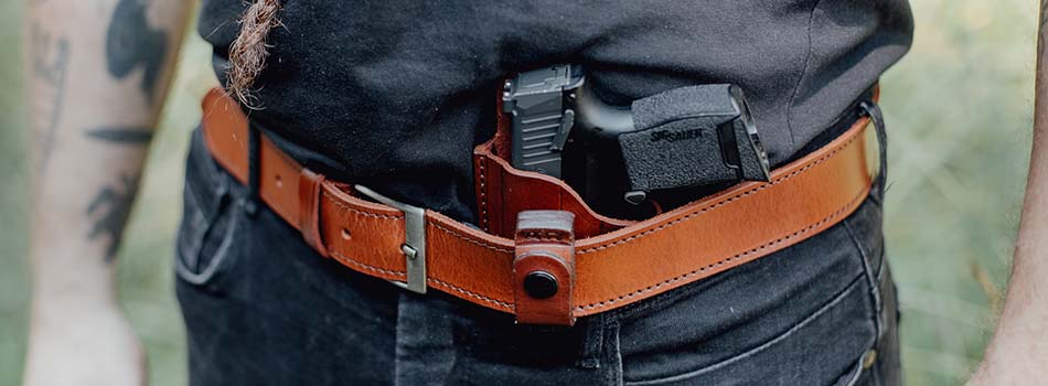 Open Carry vs Concealed Carry - picture showing man with leather belt and concealed carry method