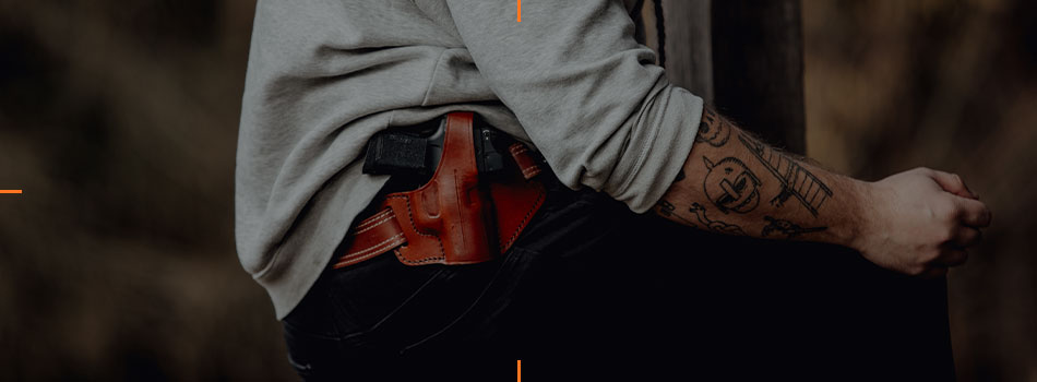 Man carrying a handgun in a brown leather OWB holster with red dot sight.