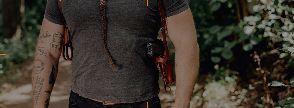 Man wearing a vertical leather shoulder holster for concealed carry.