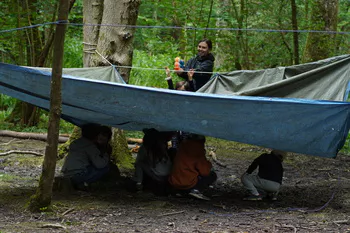 The Outdoors Project - children making dens, hiding under shelters being sprayed with water pistol in nature