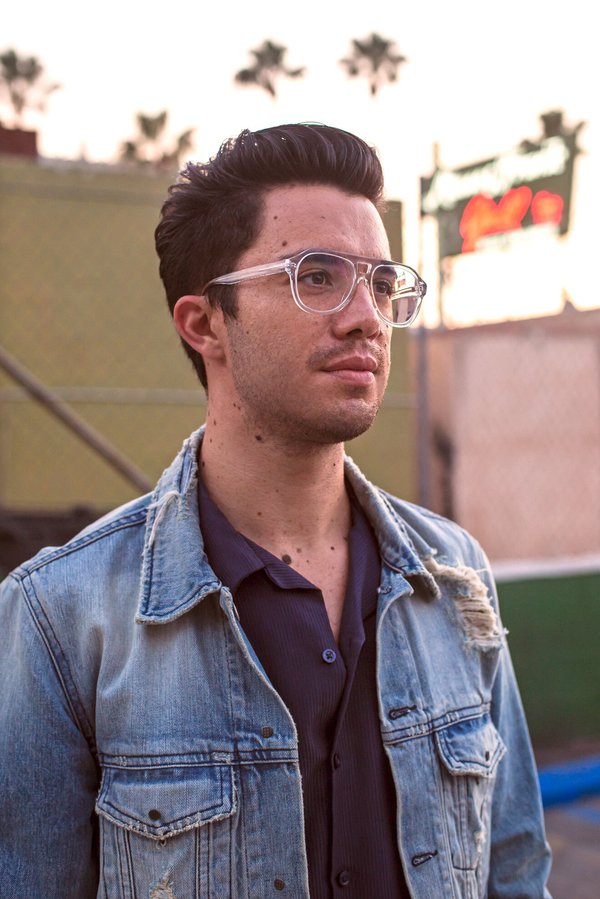 Rigel Gemini wearing a jean jacket and glasses