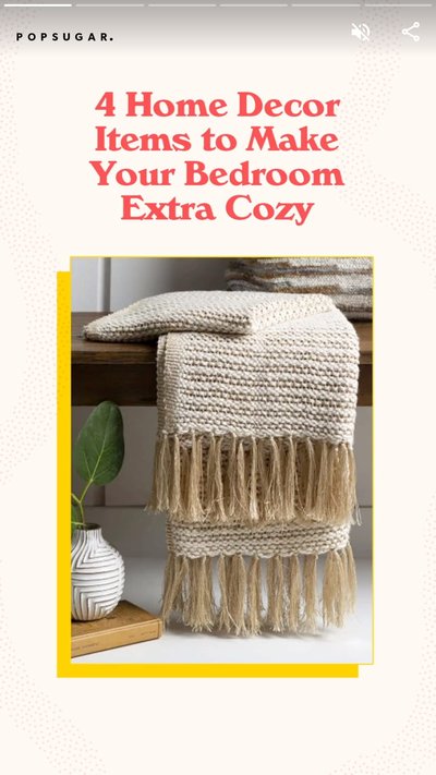 A folded white and tan blanket with tassels that is folded and placed on a small bench inside of a home