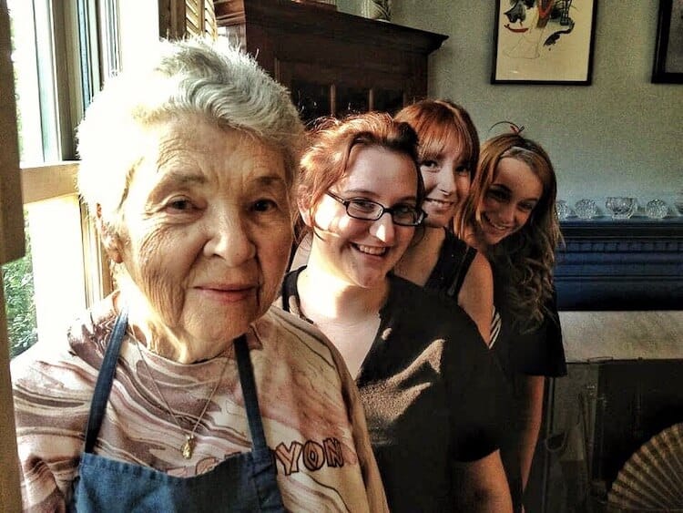 A grandmother bakes cookies with her three young granddaughters