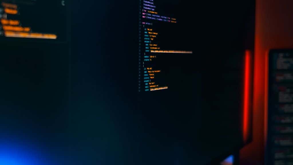 A dark monitor showing syntax-highlighted code.