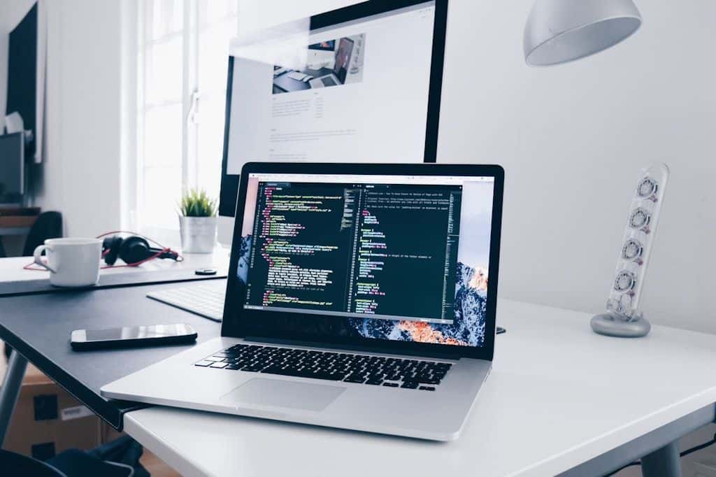 A laptop on a desk showing lines of code.