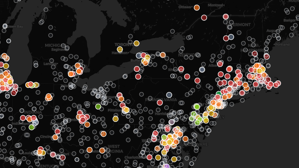 The Concrete Atlas โ Northeastern United States showing hundreds of individual ready-mix batch plants color-coded by their GCCA carbon intensity rating at 4000 PSI. Green markers indicate the lowest-carbon facilities, yellow and orange represent mid-range, red indicates the highest carbon intensity, and gray markers show plants without sufficient EPD data for rating.